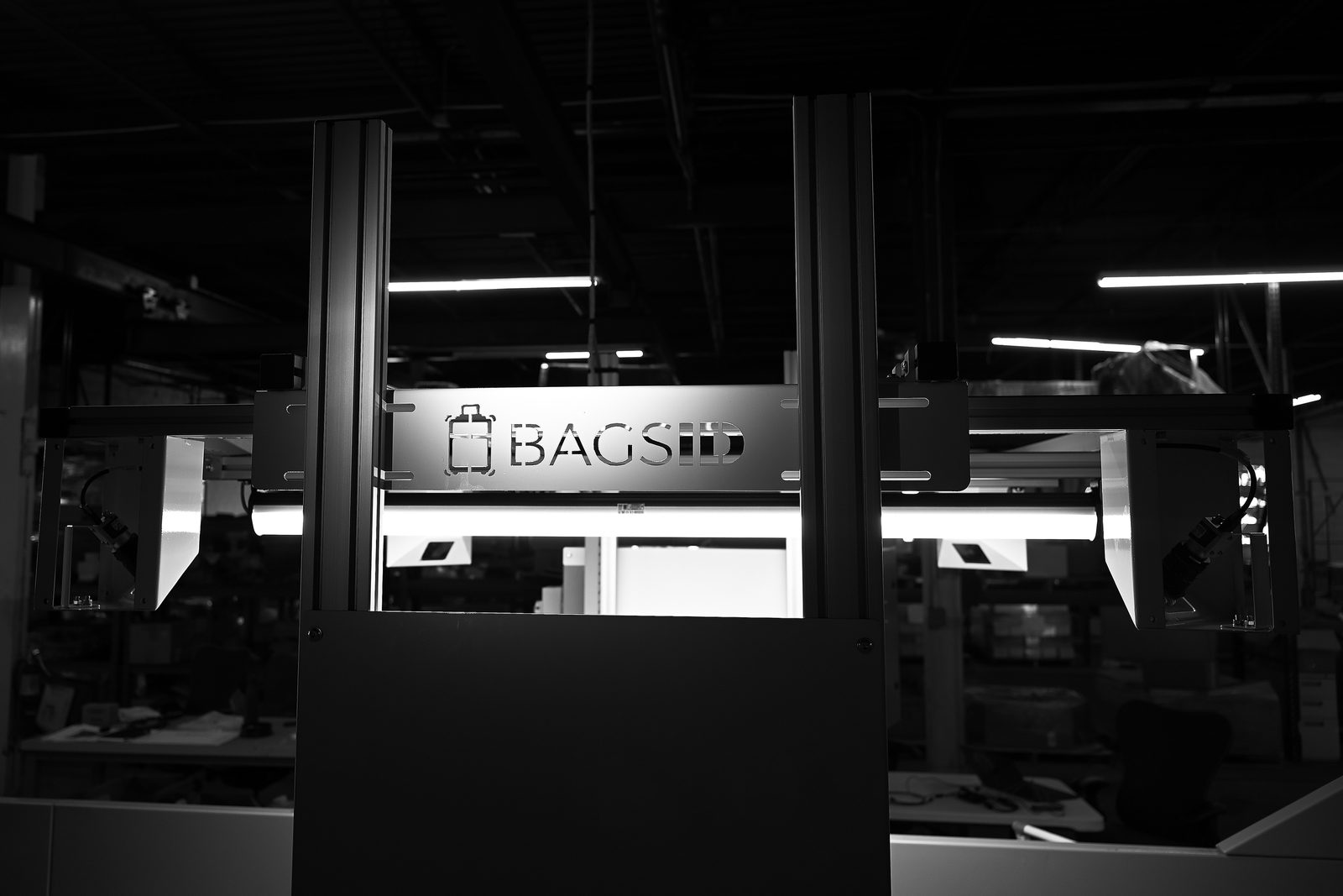 Side view of the BagsID conveyor arch with brand logo